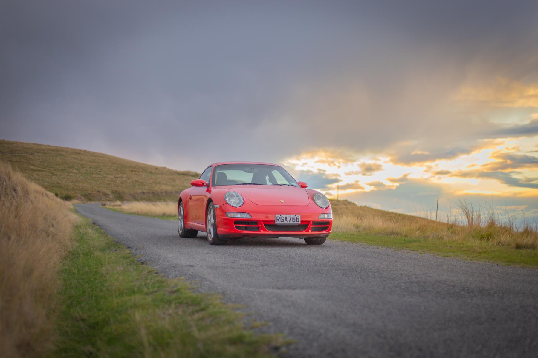Porsche 911 Carrera — golden hour on gravel